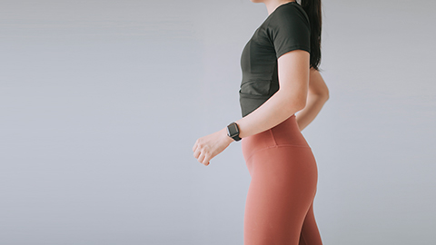 A woman in athletic wear arching her back for better posture.