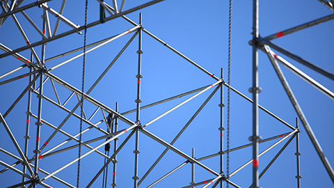 Image of scaffolding set against a bright blue sky.