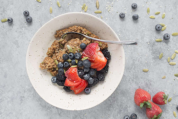 A bowl of healthy baked oatmeal with strawberries, blueberries, and blackberries