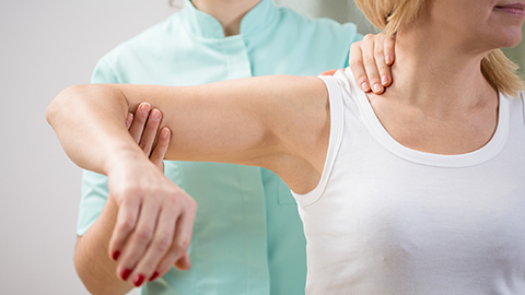 Corticobasal Syndrome--Health care worker examining woman's shoulder