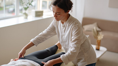 An image of a massage therapist working on their clients hip flexors.