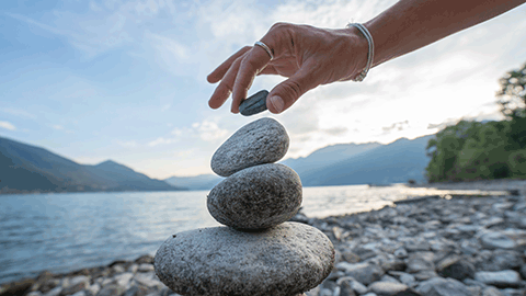 Smooth stones balanced on top of each other on a beach