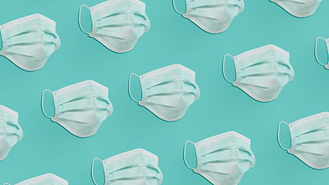 An array of surgical masks on a teal background