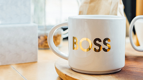 A coffee mug with the word “BOSS” emblazoned in gold lettering.