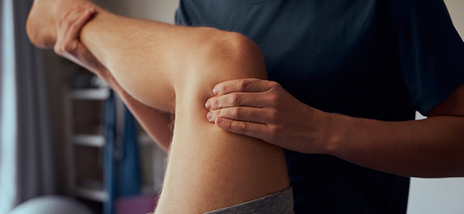 A massage therapist working on a patients knee.