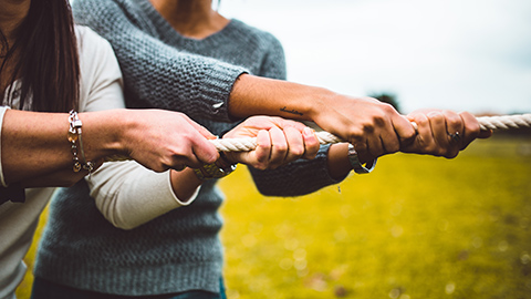 two people pulling against themselves in a game of tug-of-war.