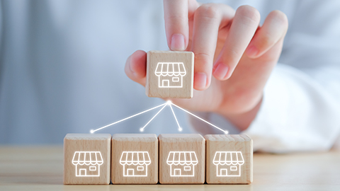 five wooden boxes with brick-and-mortar shop images etched in white.