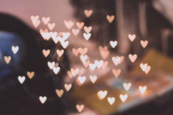 Small pink and white hearts glowing in soft light. 