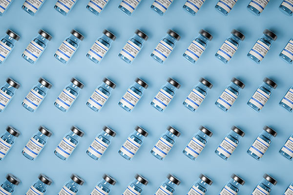 COVID-19 vaccines arrayed in rows of small glass vials