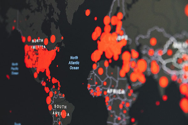 World map with data points plotted in red to show the spread of COVID-19