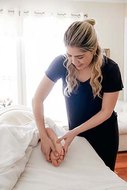 Woman massaging a patient's foot