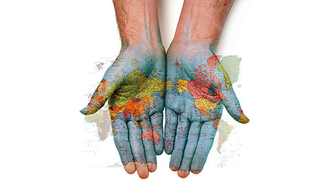 A pair of open hands with a map of the world superimposed on the palms.