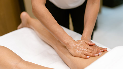Massage therapist massaging a client's hamstring.