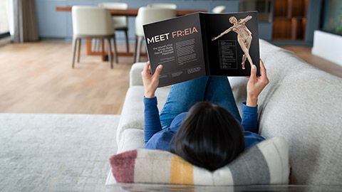 An image of a woman laying on her couch reading a magazine article about FR:EIA.