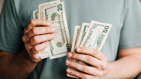 Image of a person holding cash in both hands.