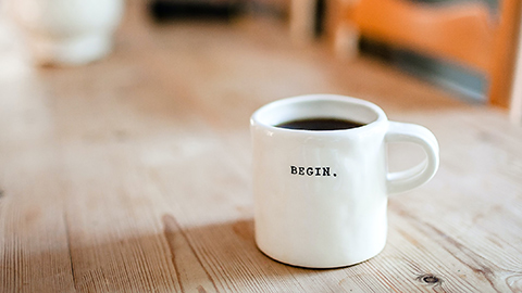 A coffee mug with the word "begin." 