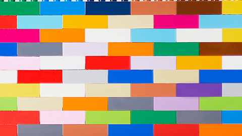 A colorful wall of stacked Lego bricks. 