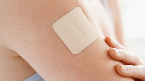 A medical patch on a woman's arm. 