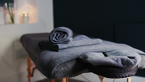 A massage table and soft towels in a tranquil treatment room.