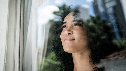 Massage therapist looking out the window with a smile.