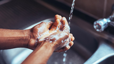 Massage therapist washing their hands at a sink.