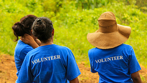 Three people wearing volunteer T-shirts