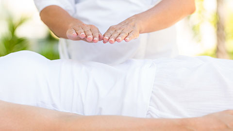 Reiki treatment performed with hands hovering over client's abdomen