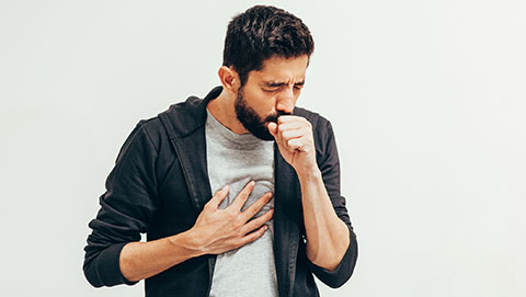 Man holding his chest and coughing